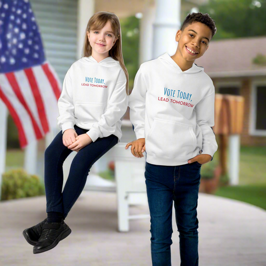  White hoodie with ‘Vote Today, Lead Tomorrow’ slogan, standing in front of a house with American flags, promoting civic engagement and voting awareness